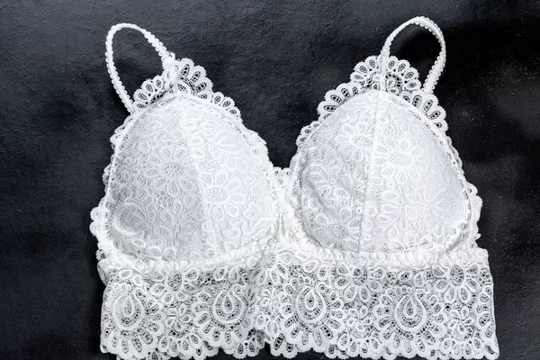 Top view white lace top bra on black background