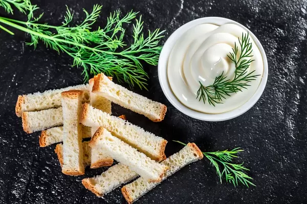 Top view white sauce and crackers with fresh dill on black stone background (Flip 2019)