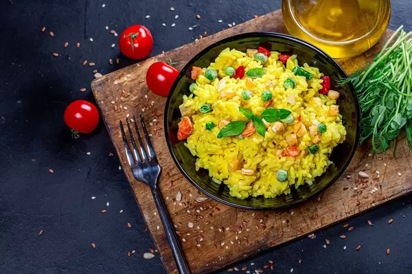 Top view yellow rice with vegetables and greens in a black bowl (Flip 2019)