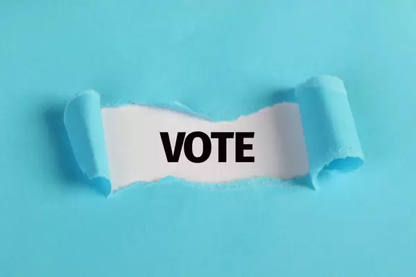 Torn paper revealing the word Vote