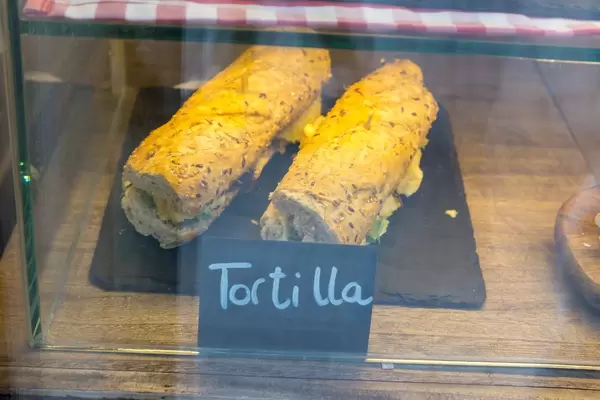 Tortilla Sandwiches mit rustikalem Brot, auf einer Schieferplatte in der Auslage präsentiert, in Barcelona (Spanien)