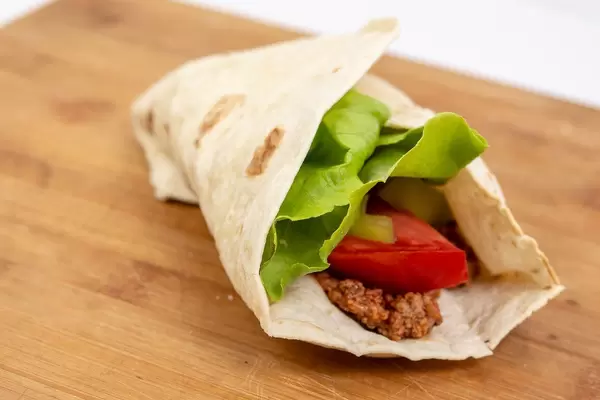 Tortilla with Minced meat Tomato and Lettuce on the wooden table