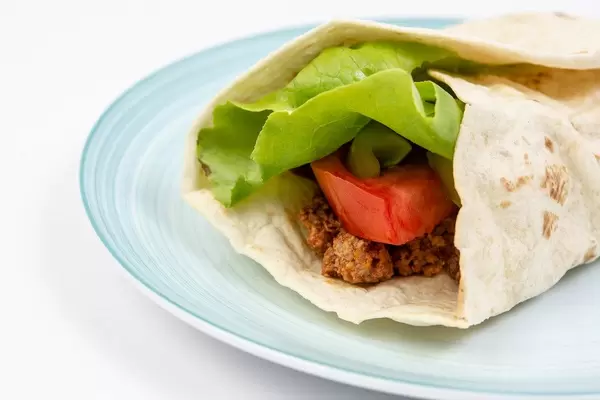 Tortilla with Minced meat Tomato Lettuce served on the plate