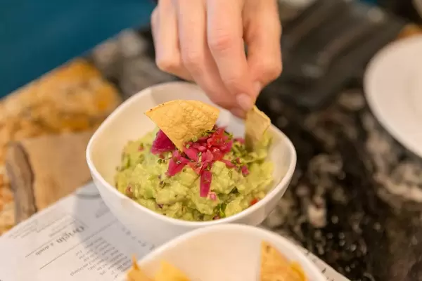 Tortillachips zum Dippen in Guacamole (Avocadocreme) als Vorspeise im Fit Kitchen Restaurant in Barcelona, Spanien