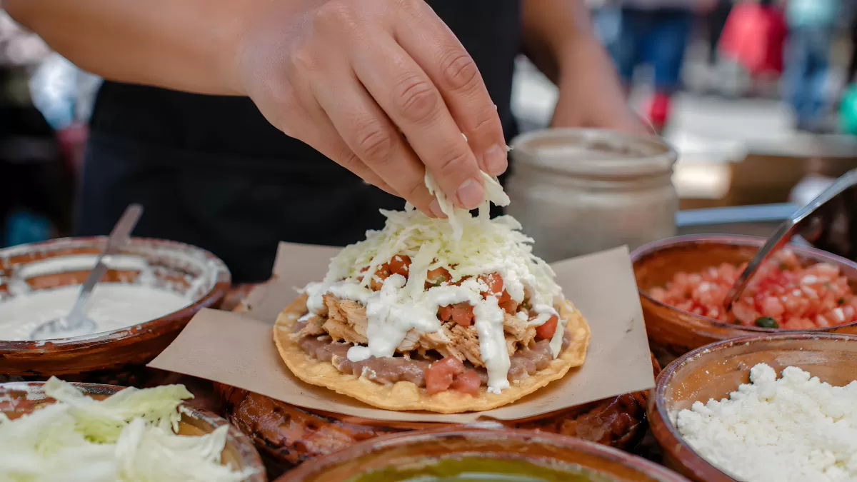 Tostada mit Hühnchen und frischen Zutaten belegen