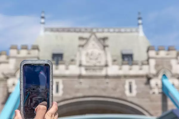 Tourist fotografiert die Tower Bridge mit dem Handy