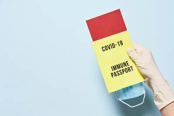 Tourist hand in medical gloves holding immune passport