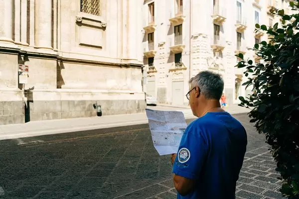 Tourist looking up directions on the map of Catania