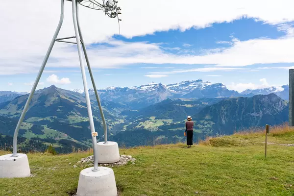 Tourist taking a picture of Swiss Alps at the edge of the world next to weather station