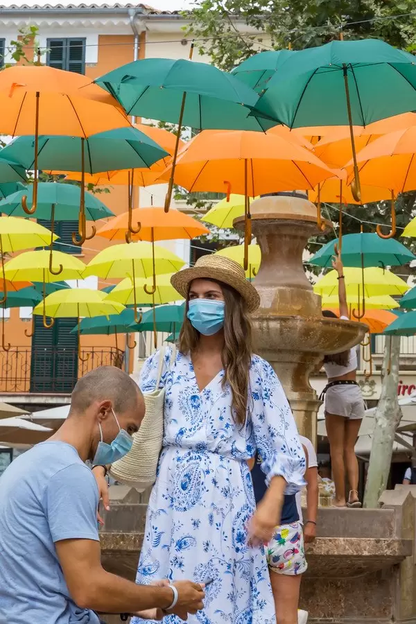 Touristen mit Mundschutz beim Fotospot in Sóller, Mallorca: Regenschirmen-Installation von V. Balaguer