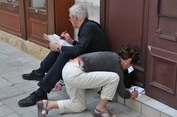 Touristen schauen sich die Stadtkarte von Wien an und schreiben Ansichtskarten