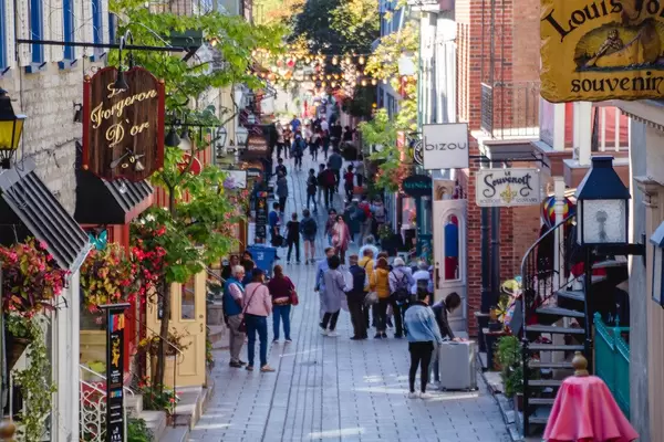 Touristische Gasse mit Souvenirläden, Blumen und Lichterketten