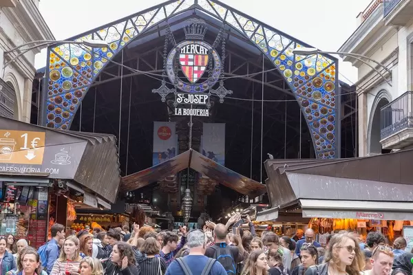 Tourists and visitors in front of the largest and most famous market hall for food "Mercat de Sant Josep" at La Rambla in Barcelona, Spain