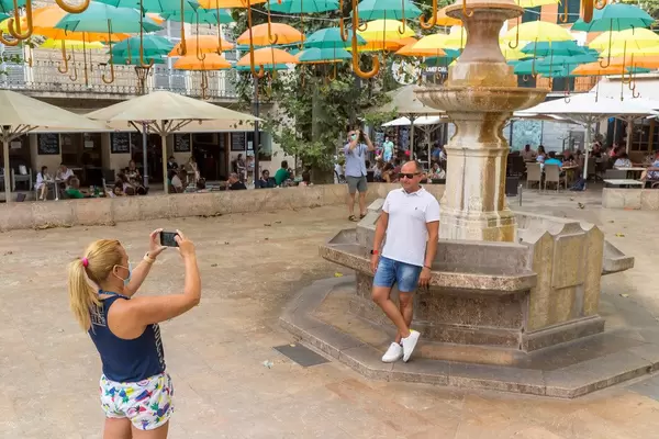 Tourists with face mask at photo spot in Sóller, Majorca: the new "suspended umbrellas" installation