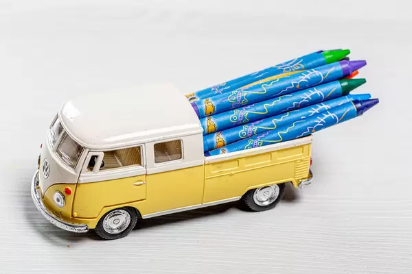Toy car with colored pencils in the trunk. The concept of children's time in school