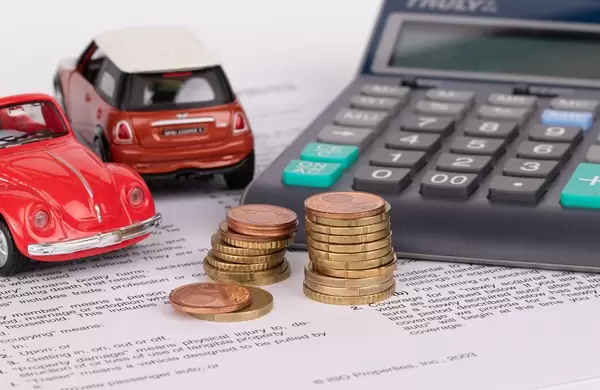 Toy cars, calculator and stack of coins