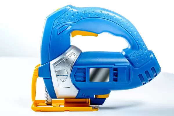 Toy electric jigsaw on white background