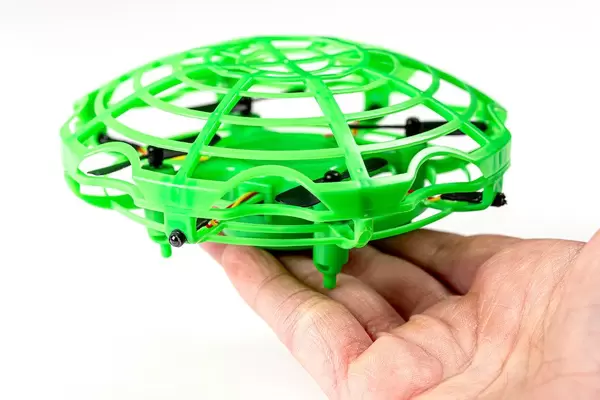 Toy green flying drone in a hand (Flip 2020)