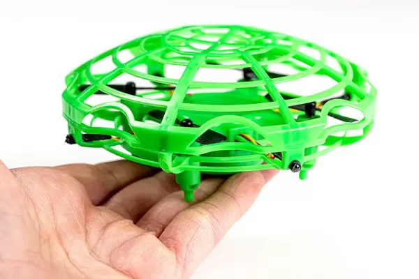 Toy green flying drone in a hand