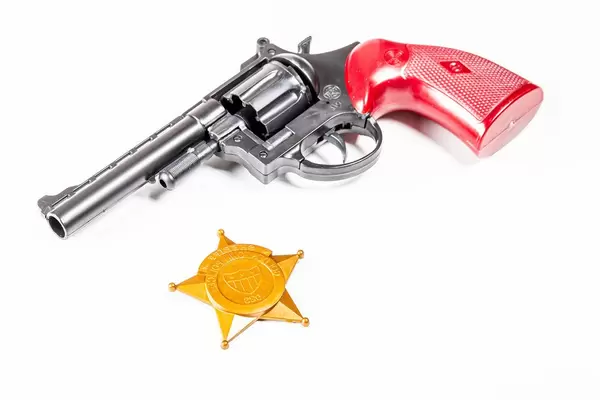 Toy gun with police badge on white background (Flip 2020)