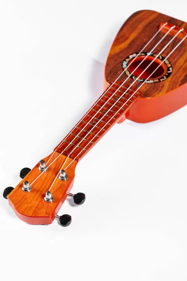 Toy Hawaiian guitar ukulele on white background