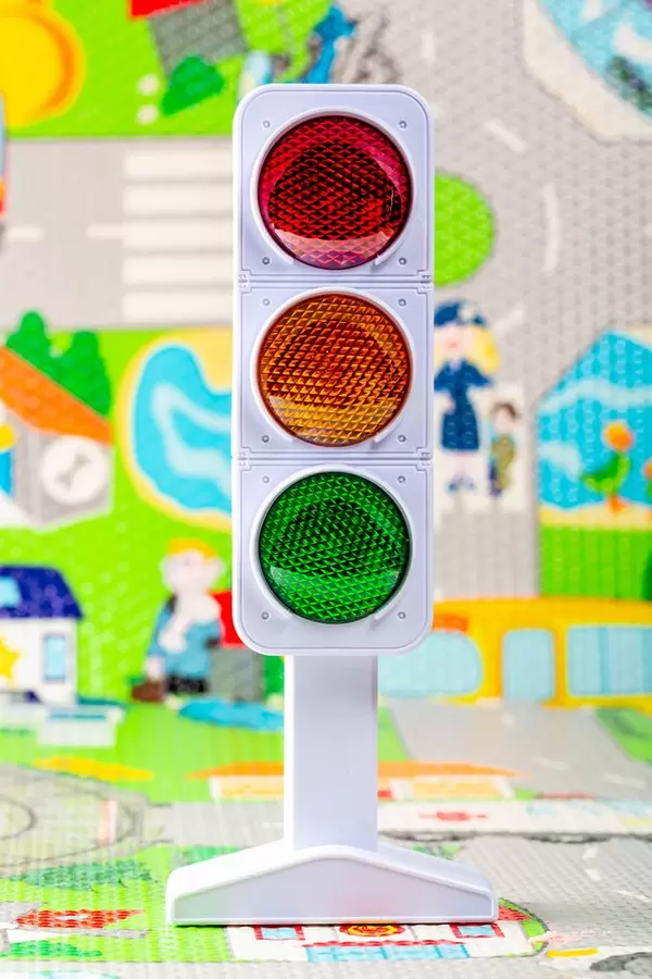 Toy model of traffic light with the image of the road in the background
