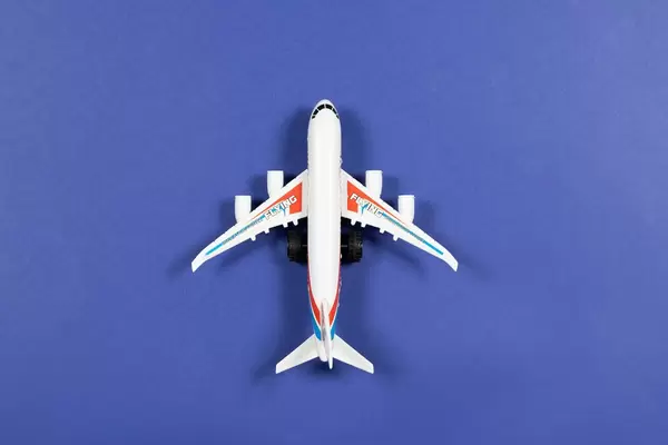 Toy plane on blue paper background