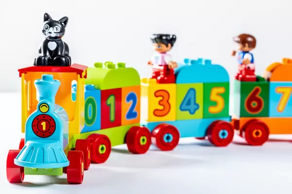Toy train with wagons carries kids and cat