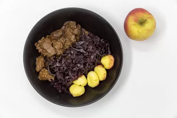 Traditional beef stew with apple beetroot salad and potato dumplings - top view