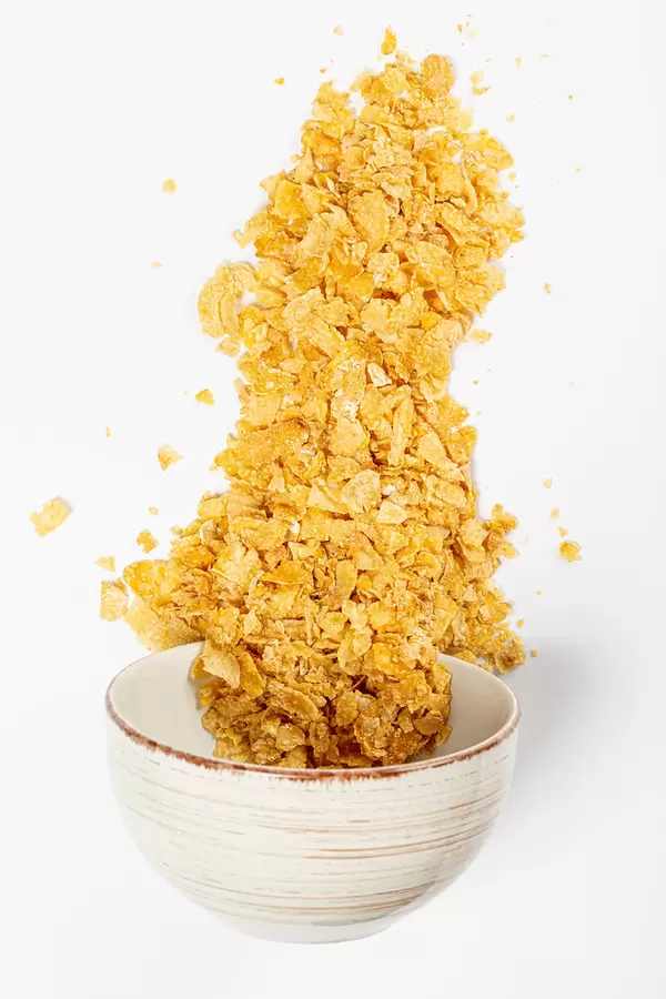 Traditional breakfast of corn flakes poured out of the bowl