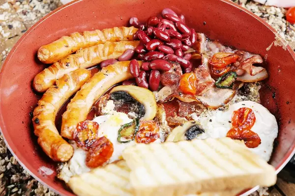 Traditional English breakfast in frying pan, close-up view