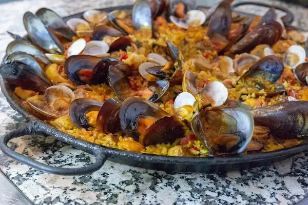 Traditional spanish paella with fresh mussels in a cast iron pan