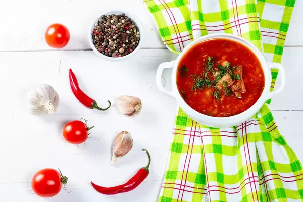 Traditional Ukrainian and Russian soup borsch with spices on a white wooden table