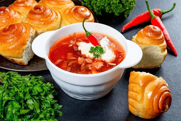 Traditional Ukrainian borscht with meat, vegetables and sour cream on a black background (Flip 2019)