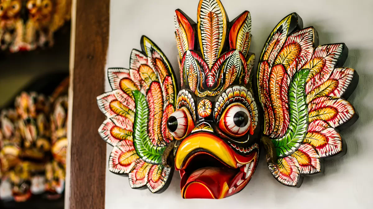 Traditionelle balinesische Holzmaske mit bunten Federn
