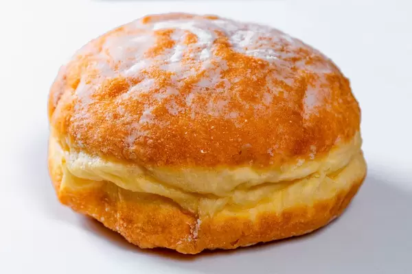 Traditioneller Krapfen mit Puderzucker vor weißem Hintergrund