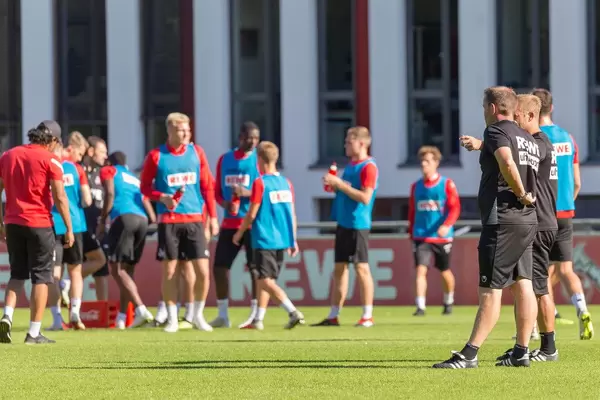 Trainer unterhalten sich während Spieler Wasser trinken