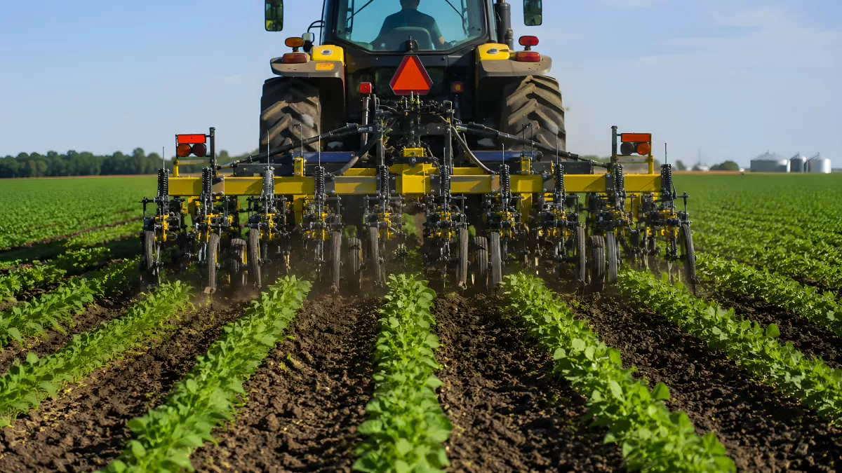 Traktor bei der Bodenbearbeitung auf grünem Feld