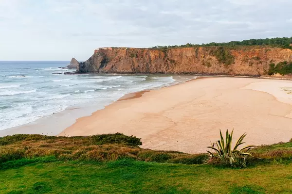 Traumhafter Sandstrand zwischen steilen Klippen bei Cabo de Sao Vicente, Portugal
