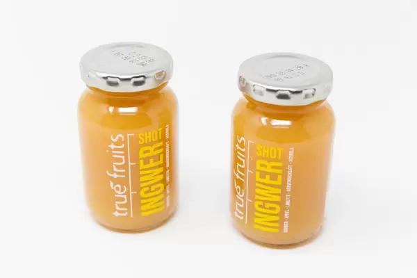 Trendgetränk: zwei Ingwer Shot yellow von true fruits vor weißem Hintergrund