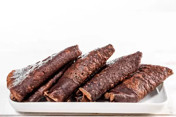 Triangles with chocolate brown pancakes on a white plate (Flip 2019)