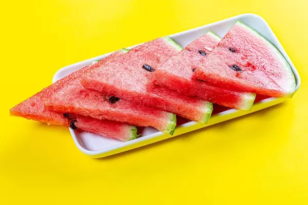 Triangular pieces of ripe red watermelon on a yellow background (Flip 2019)