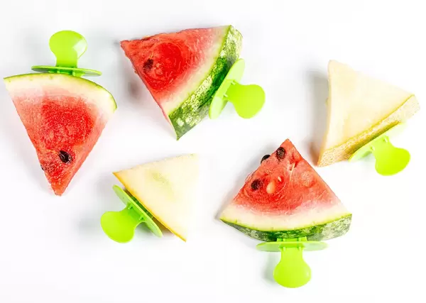 Triangular slices of fresh melon and watermelon on white, top view