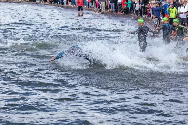 Triathletes start the Ironman swimming competition in the south of Finland at Lake Vesijärvisee and jump into the water