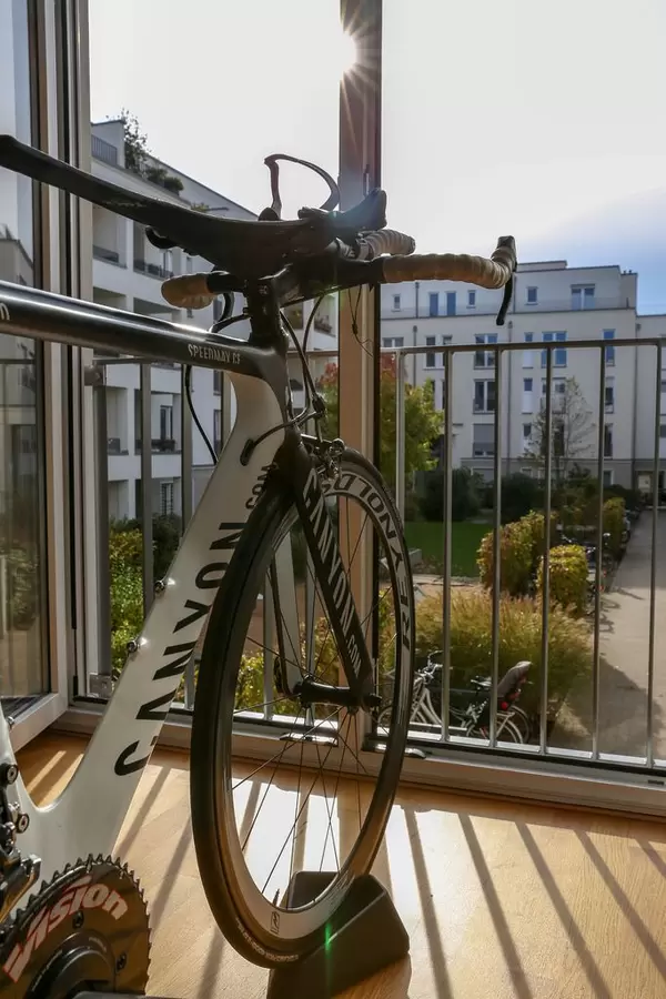 Triathlon Rollentraining mit einem Canyon Speedmax CF vor offenem Fenster mit Sicht nach draußen
