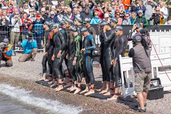 Triathlon-Wettkämpfer stehen kurz vor dem Ironman-Start in Neoprenanzügen zum Schwimmwettkampf bereit