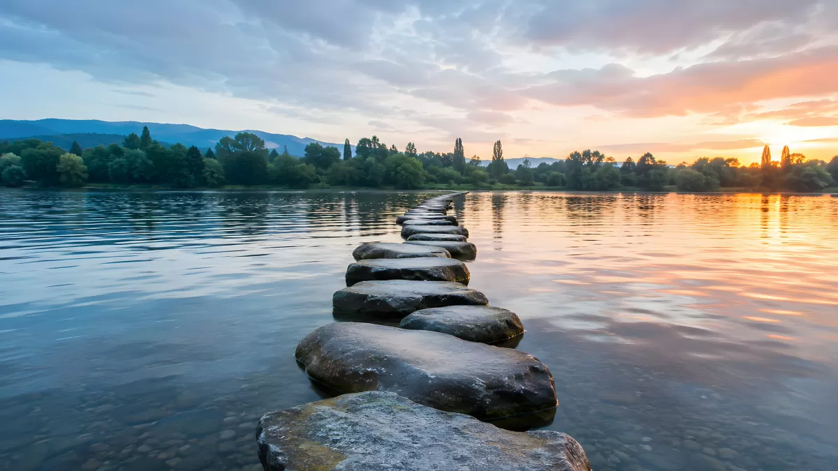Trittsteine über ruhigen See im Sonnenuntergang