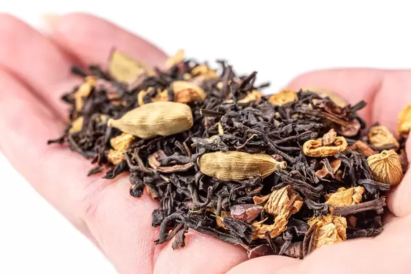 Trockener Schwarzer Gewürztee auf der Hand. Nahaufnahme