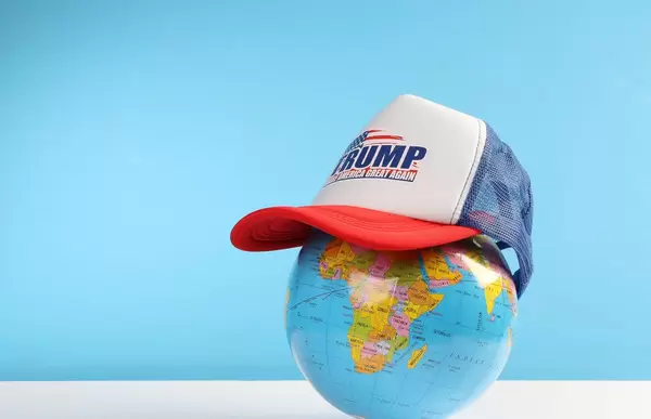 Trump classic trucker hat on a globe with blue background