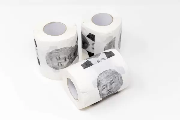 Trump Toilettenpapier vor weißem Hintergrund: 3 Rollen mit dem Gesicht vom US-Präsident als Scherz
